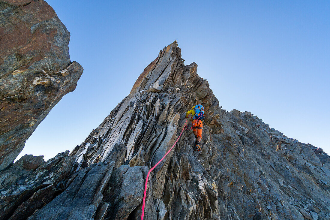ALpinist climbing along Nadelgrat ridge over 4000 meters of altitude. Nadelgrat ridge, Mattertal, Canton Vallese, Alps, Switzerland.