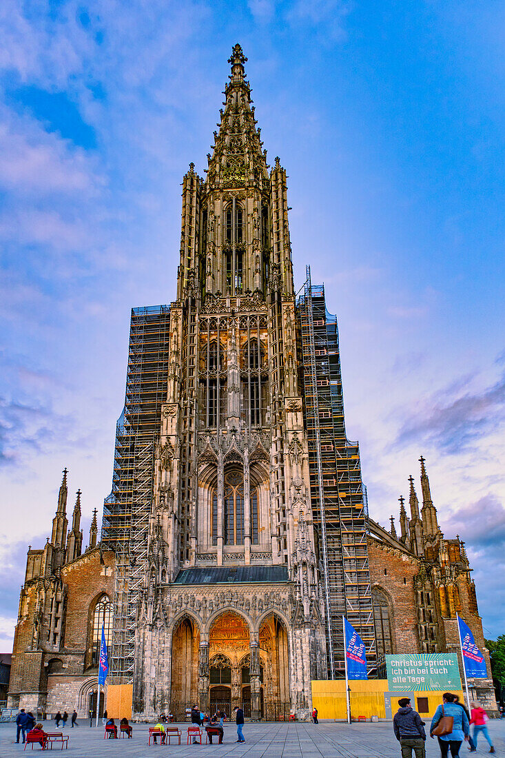 Tourists admire the Ulm Cathedral, an art-rich Gothic-style Lutheran church with the tallest bell tower in the world at dusk. Ulm, Tübingen, Donau-Iller region, Germany, Europe