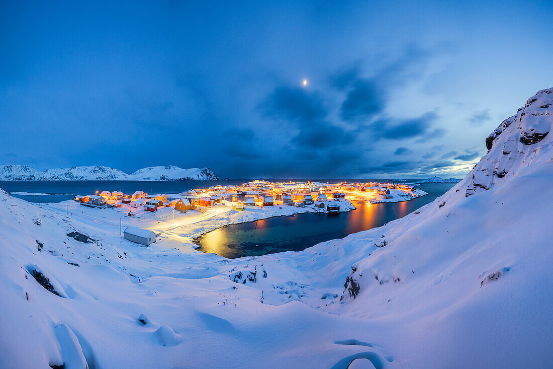 Das Küstendorf Sorvaer ist während der Dämmerung im kalten arktischen Winter mit Schnee bedeckt (Insel Soroya, Hasvik, Troms og Finnmark, Norwegen)