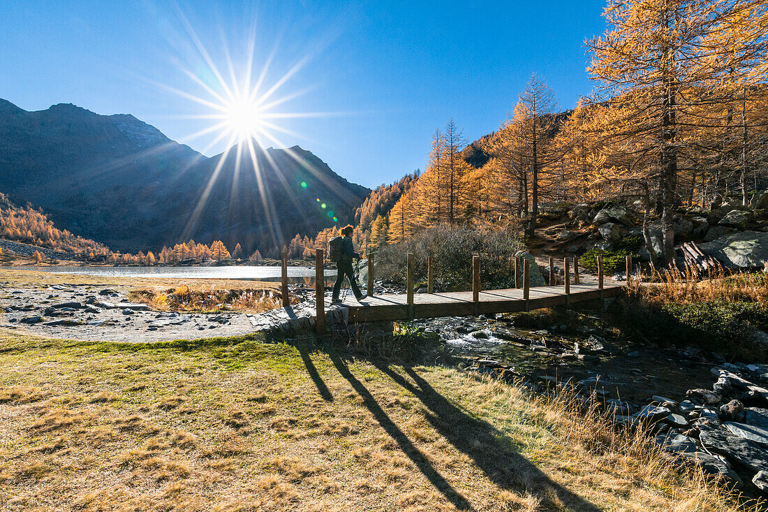 Ein Mädchen spaziert am Arpy-See im Herbst (Morgex, Provinz Aosta, Aostatal, Italien, Europa) (MR)