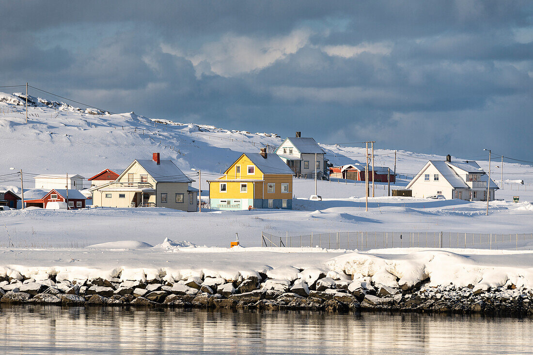 Hasvik Village: houses covered with snow during the cold arctic winter (Soroya Island, Troms og Finnmark, Norway)