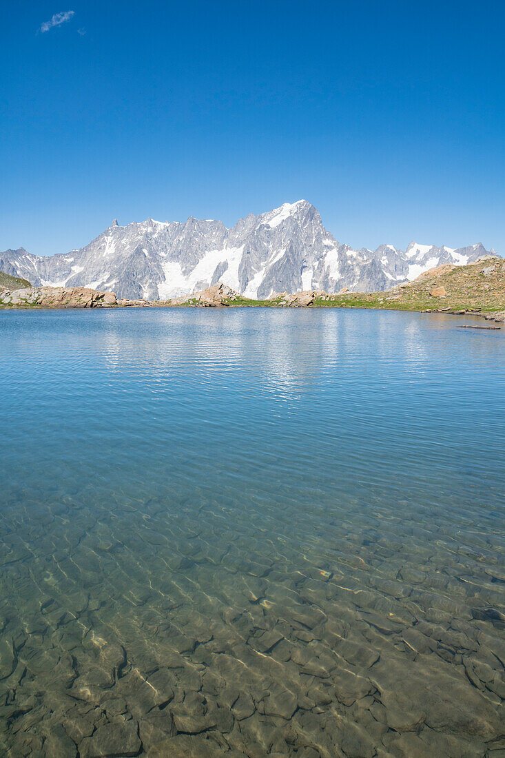 The Grandes Jorasses reflected in a small lake under the Tete de Licony. Bivouac Pascal, Morgex, Aosta Valley, Alps, Italy, Europe.