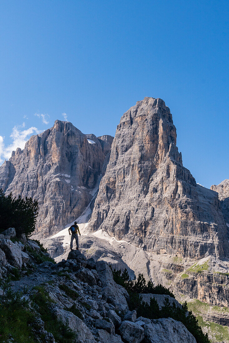 Ein Wanderer in der Silhouette entlang des Weges zum Rifugio Pedrotti von Madonna di Campiglio mit dem Berg Tosa im Hintergrund. Madonna di Campiglio, Trentino, Italien.