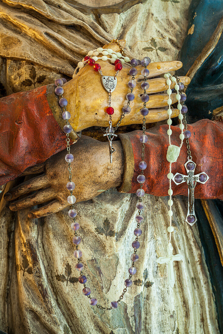 Devotional rosaries in the hands of the wooden statue of Mary. Abruzzo, Italy, Europe