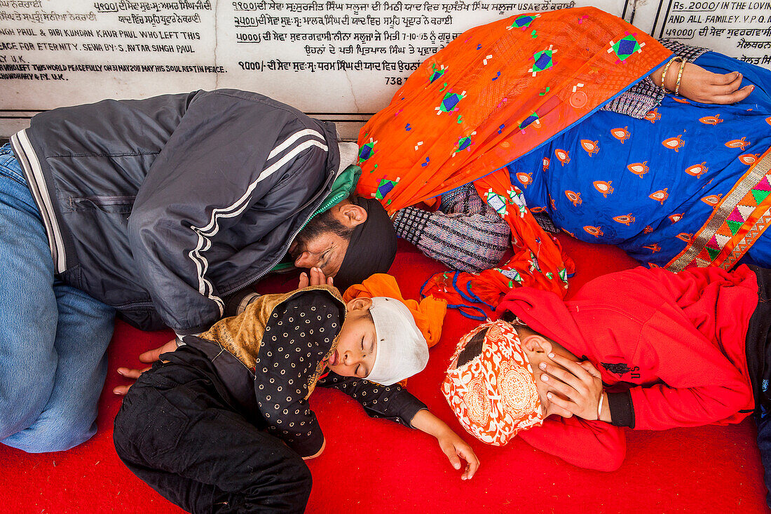 Schlafende Pilger (Familie), nach einer anstrengenden Reise, im Inneren des Goldenen Tempels, Amritsar, Punjab, Indien