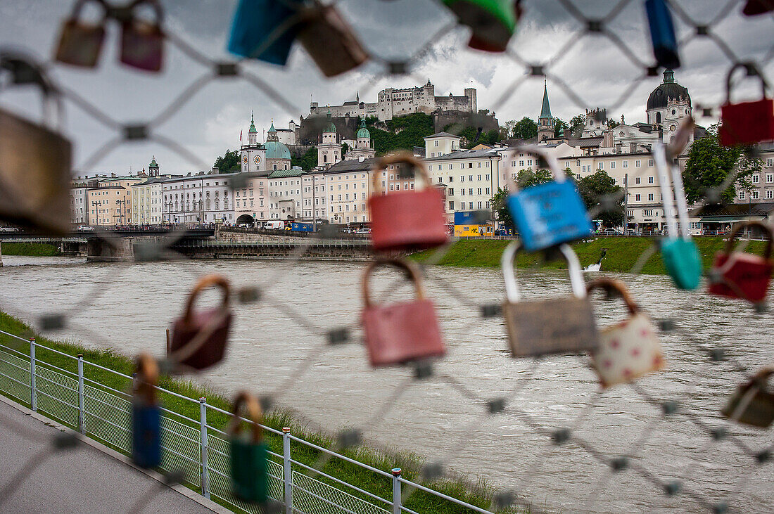 Panoramic view of Salzburg castle and Old Town, through symbolic love padlocks fixed to the railings of Makartsteg footbridge, Salzburg, Austria