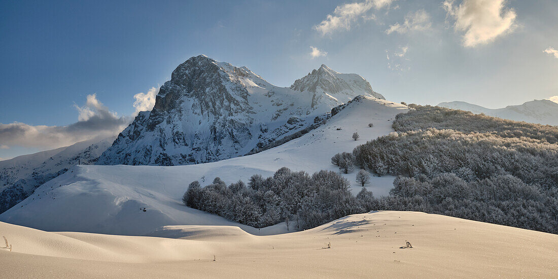 Gentle hills covered of fresh snow leading to Gran Sasso highest peaks at sunset. Pietracamela, Teramo district, Abruzzo, Italy