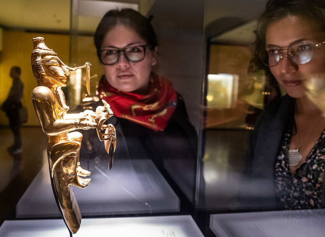Visitors observing Poporo, anthropomorphous, Pre-Columbian goldwork collection, Gold museum, Museo del Oro, Bogota, Colombia, America