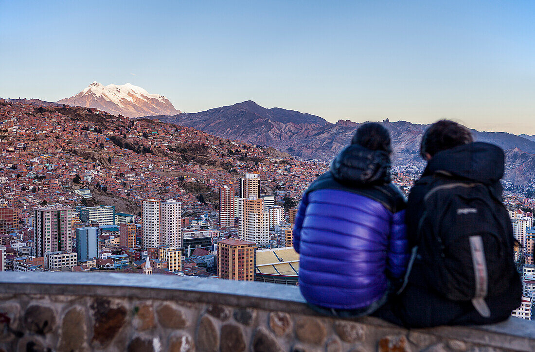 Couple and Panoramic view of the city, in background Illimani mountain 6462 m, La Paz, Bolivia