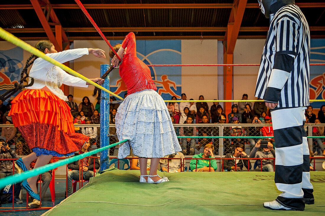 Lucha Libre. Kampf zwischen Dina mit orangenem Rock und Benita la Intocable , cholitas Ringerinnen, mit Schiedsrichter, Sportzentrum La Ceja, El Alto, La Paz, Bolivien