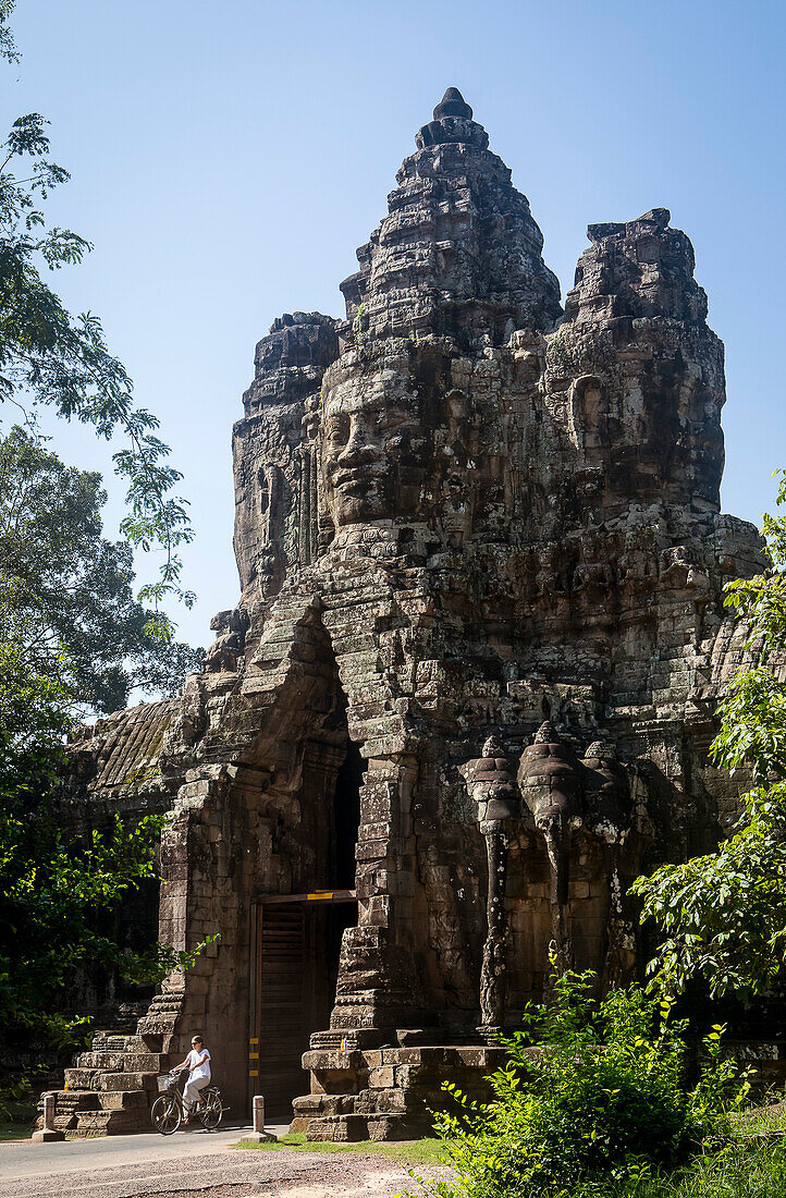 Woman biking, South Gate of Angkor Thom, Angkor, Siem Reap, Cambodia