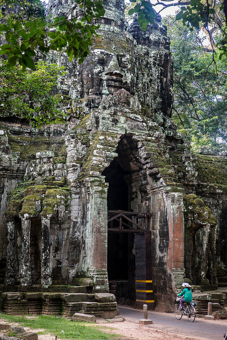 Woman biking, North Gate of Angkor Thom, Angkor, Siem Reap, Cambodia