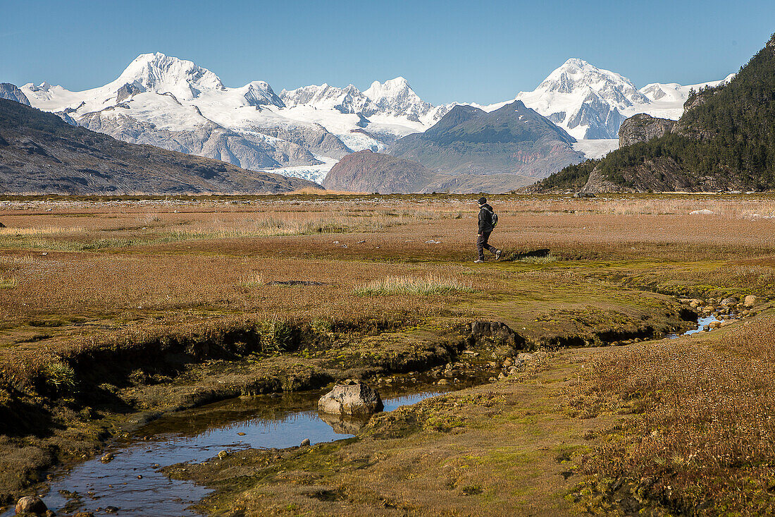 Eine Person erkundet das Innere der Ainsworth-Bucht, im Hintergrund Cordillera Darwin, PN Alberto de Agostini, Tierra del Fuego, Patagonien, Chile