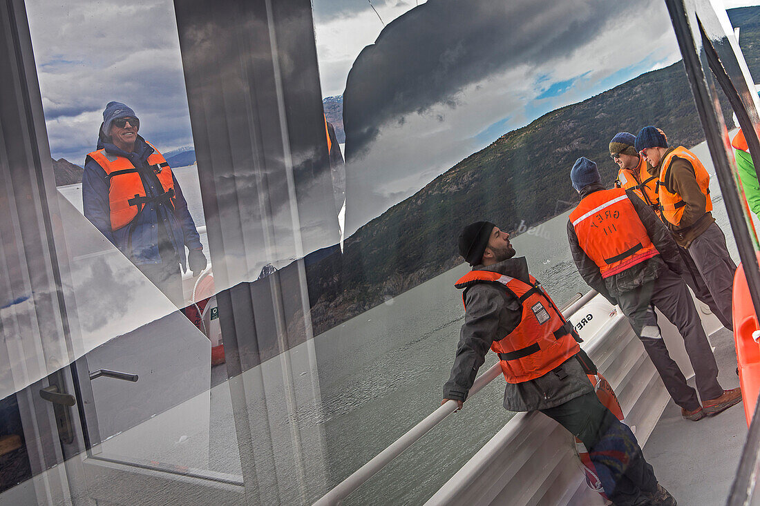 Reflections, Hikers in a Catamaran, crossing Grey lake between Refugio Grey and Hotel Lago Grey, Torres del Paine national park, Patagonia, Chile