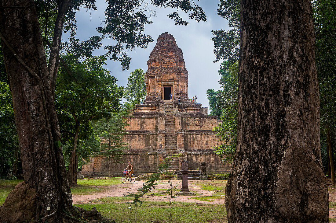 Frau beim Radfahren, Baksei Chamkrong Tempel, Archäologischer Park von Angkor, Siem Reap, Kambodscha