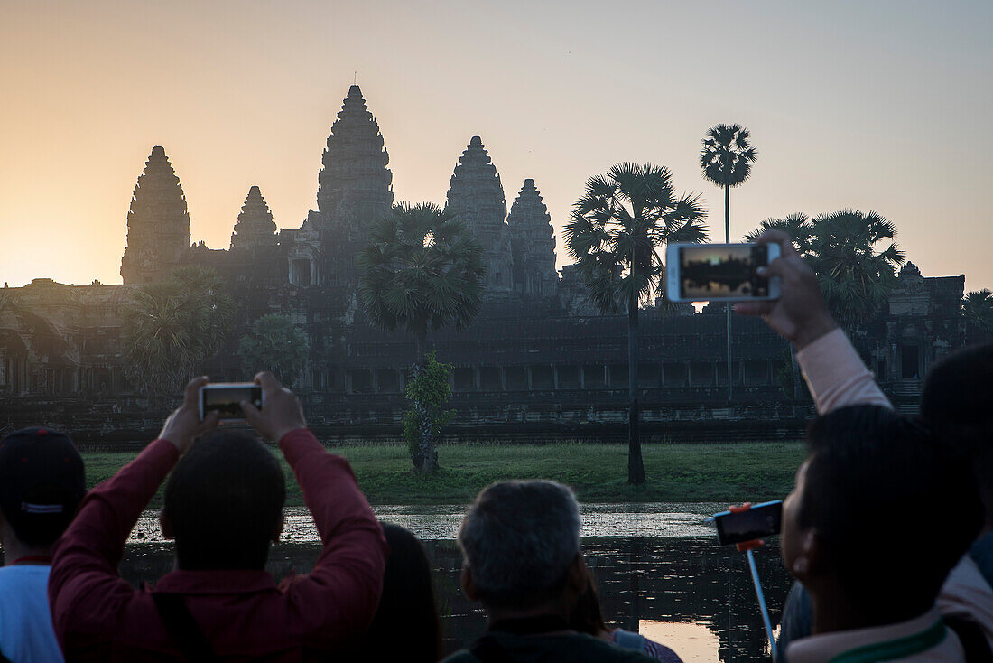 Touristen beobachten den Sonnenaufgang in Angkor Wat, Siem Reap, Kambodscha