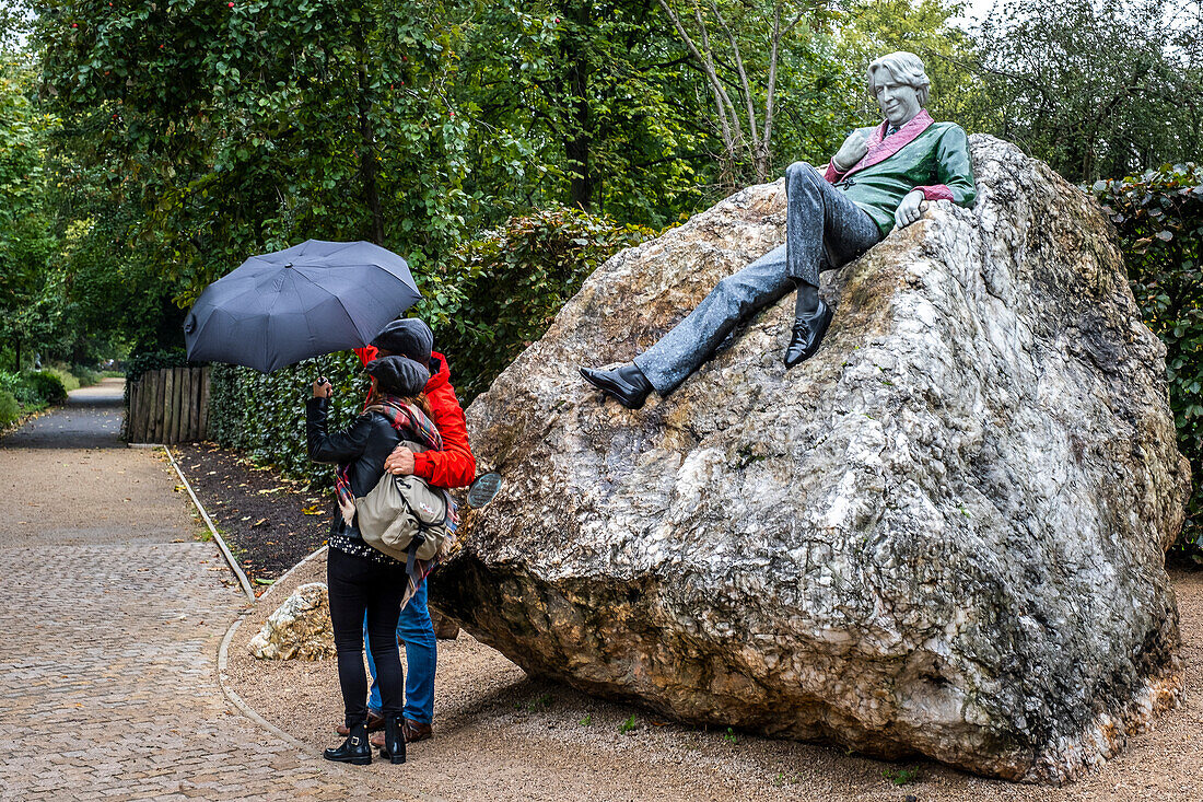 Selfie, tourists and statue of Irish writer Oscar Wilde by Danny Osbourne in Merrion Square, Dublin, Ireland