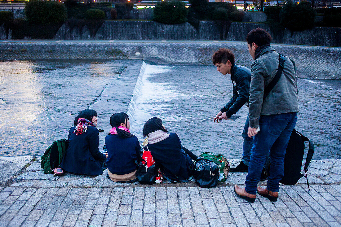 Men talking to girls,Kamo river at Pontocho,Kyoto, Japan