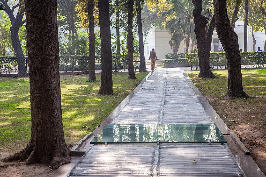 Wache an der Stelle, an der Indira Gandhi getötet wurde, Indira Gandhi Memorial Museum. Der Ort, an dem ihre Sikh-Leibwächter aufsprangen, um 31 Kugeln in sie zu verschießen. Die letzten Schritte, die sie an diesem Tag ging, sind mit einem durchsichtigen Material bedeckt, und die glatte Glasscheibe markiert die Stelle, an der sie auf dem Boden zusammenbrach. Neu-Delhi, Indien