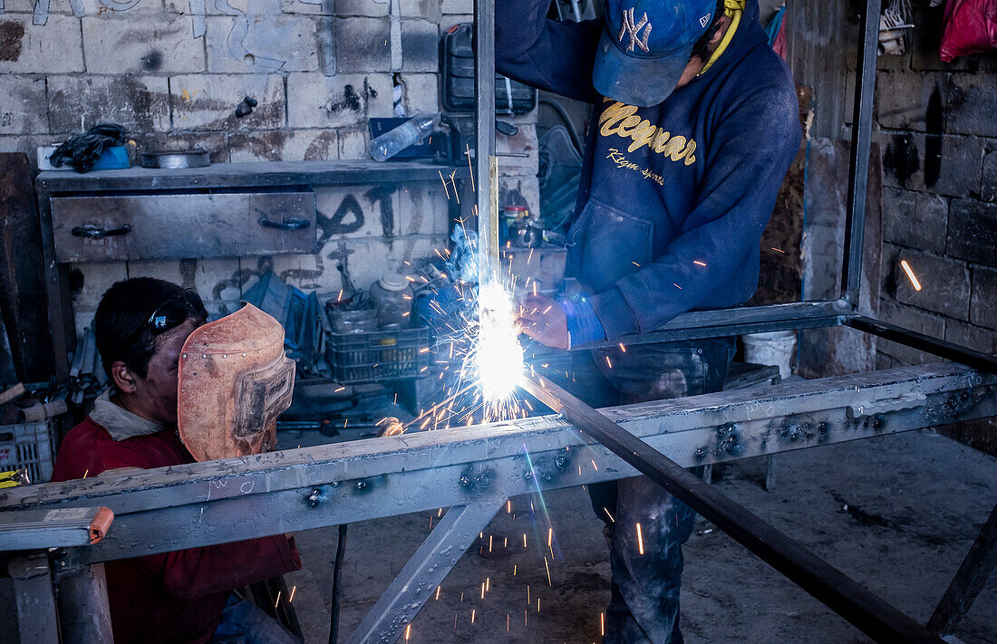 At right Ahmad, 16 years old, and Ahmad, 11 years Old, working with metals and dangerous machinery, child labour, syrian refugees, in Arsal, Bekaa Valley, Lebanon