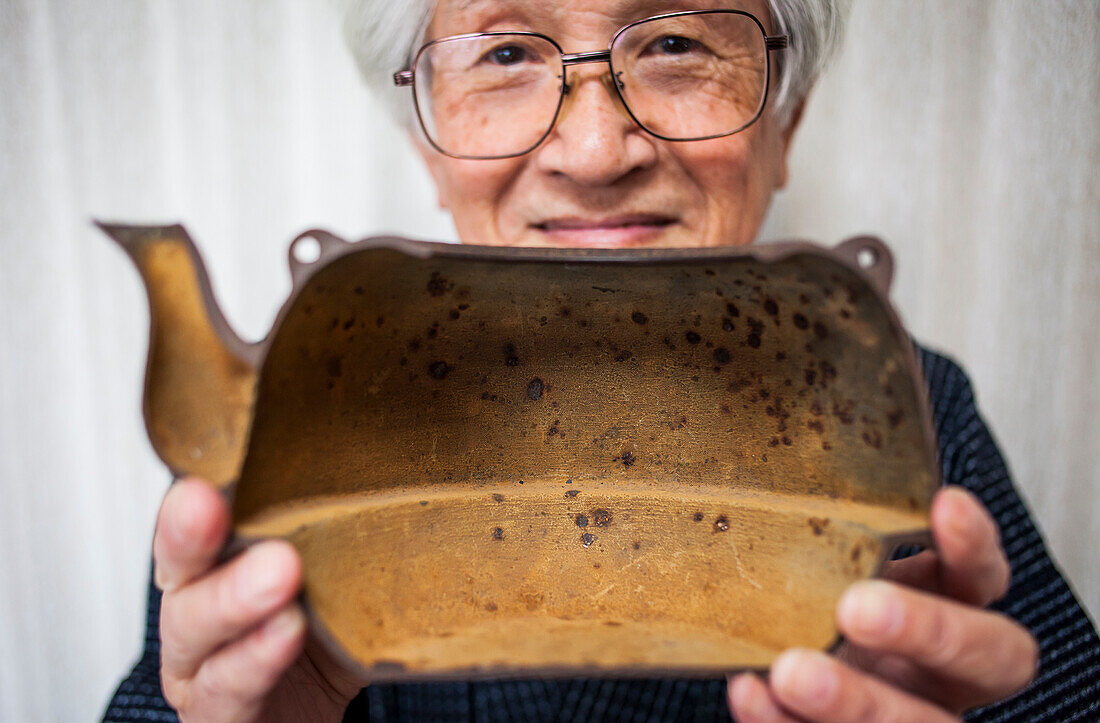 Nizaemon Koizumi zeigt das rostige Innere einer eisernen Teekanne oder tetsubin, nanbu tekki, Werkstatt der Familie Koizumi, Handwerker seit 1659, Morioka, Präfektur Iwate, Japan