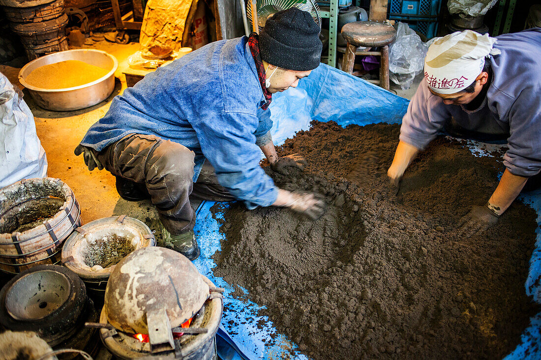Takahiro Koizumi at right and his assistant kohei ishimori at left are making mud to build a molds to make a iron teapot or tetsubin, nanbu tekki,Workshop of Koizumi family,craftsmen since 1659, Morioka, Iwate Prefecture, Japan