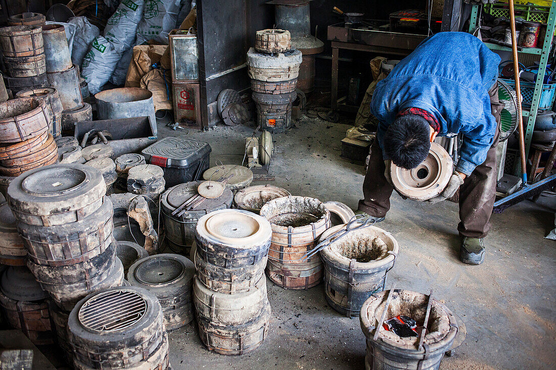 Kohei Ishimori überprüft, ob die äußeren Formen richtig gekocht sind, um dem geschmolzenen Eisen zu widerstehen und eine eiserne Teekanne oder Tetsubin herzustellen, nanbu tekki, Werkstatt der Familie Koizumi, Handwerker seit 1659, Morioka, Präfektur Iwate, Japan