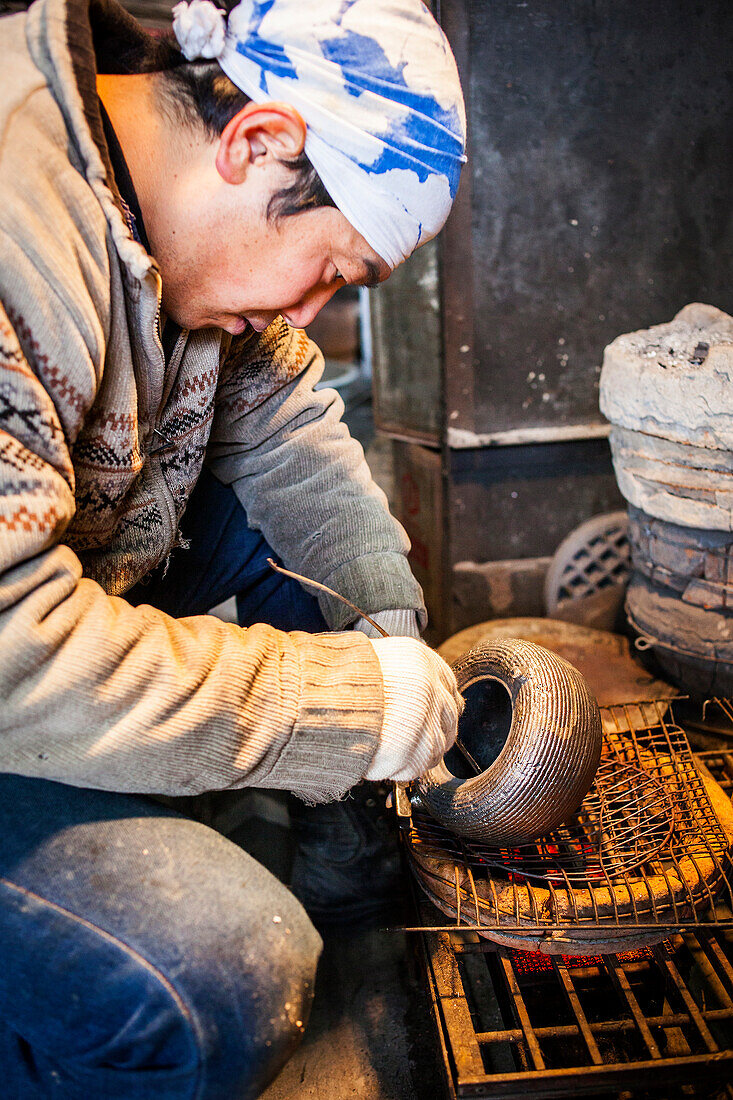 Takahiro Koizumi is putting the finishing touches at iron teapot or tetsubin, nanbu tekki, Workshop of Koizumi family,craftsmen since 1659, Morioka, Iwate Prefecture, Japan