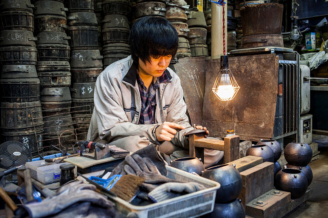 Handwerker legt letzte Hand an die eiserne Teekanne oder tetsubin, nanbu tekki, in der Werkstatt von Morihisha Suzuki, Handwerker seit 1625, Morioka, Präfektur Iwate, Japan