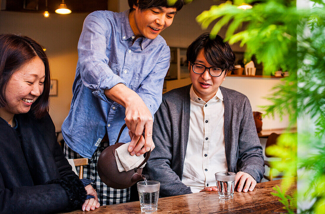 Kellner serviert Tee mit eiserner Teekanne oder Tetsubin, im Carta Cafe, Morioka, Präfektur Iwate, Japan