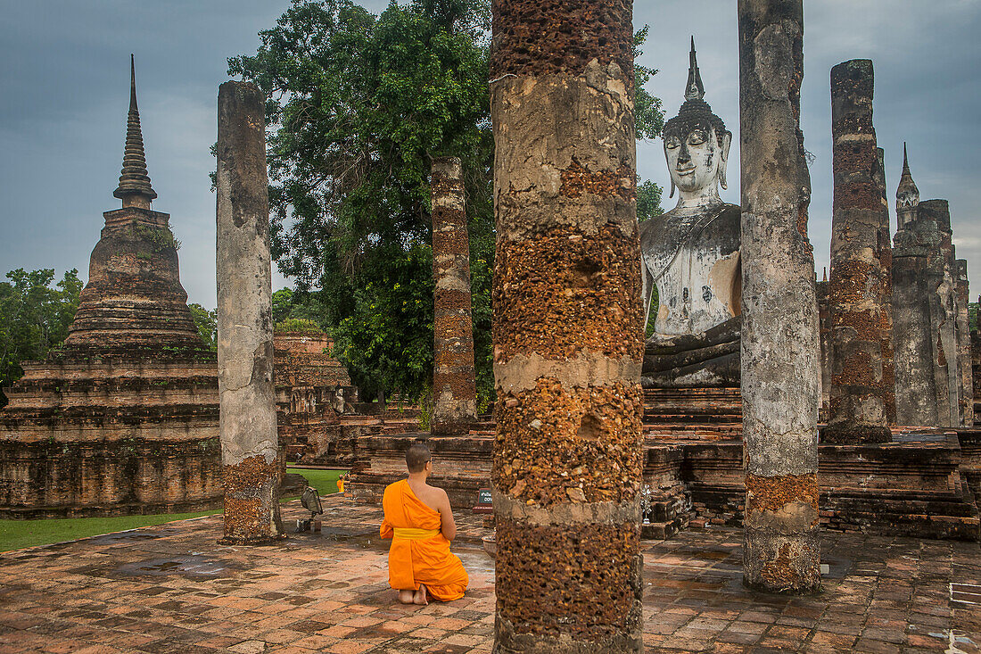 Monk praying, in Wat Mahathat, Sukhothai Historical Park, Sukhothai, Thailand
