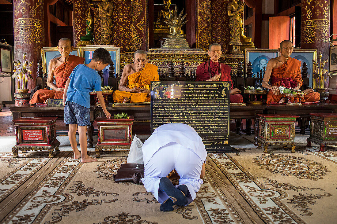 Betende Personen, Mönchsstatue, im Wat Phra Singh Tempel, Chiang Mai, Thailand