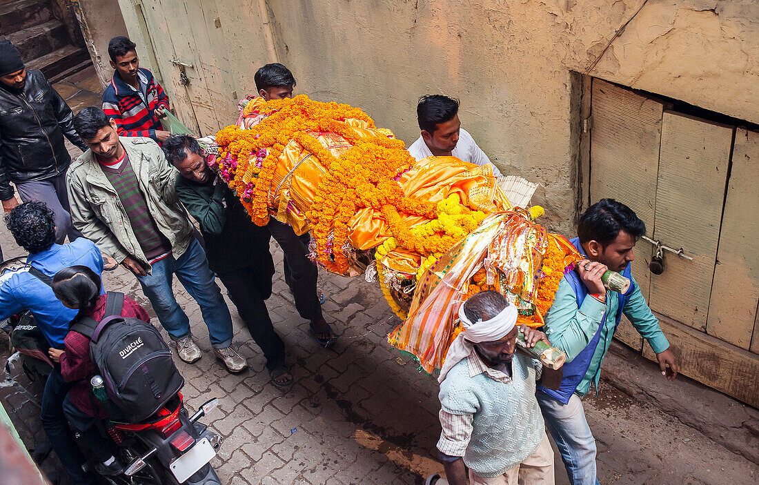 Menschen tragen eine Leiche zur Verbrennung zum Manikarnika Ghat, dem Verbrennungsghat, Varanasi, Uttar Pradesh, Indien.