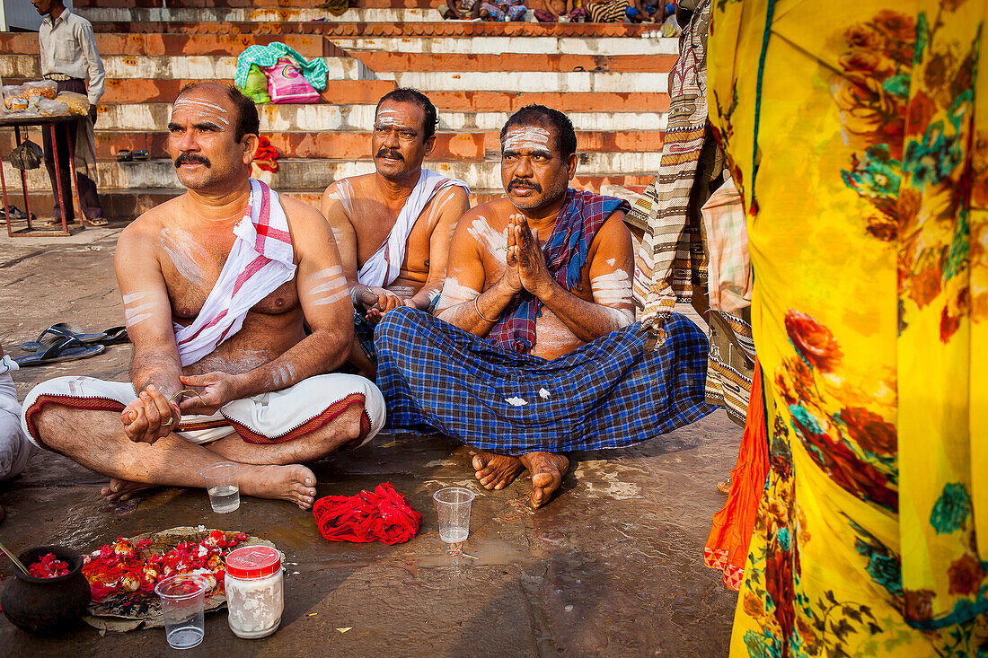 Pilger, die eine rituelle Opfergabe darbringen und beten, Ghats im Fluss Ganges, Varanasi, Uttar Pradesh, Indien.