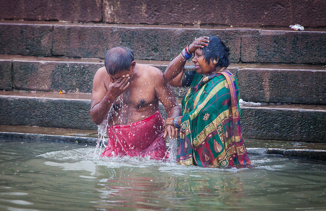 Pilgrims praying and bathing, in the ghats of Ganges river, Varanasi, Uttar Pradesh, India.
