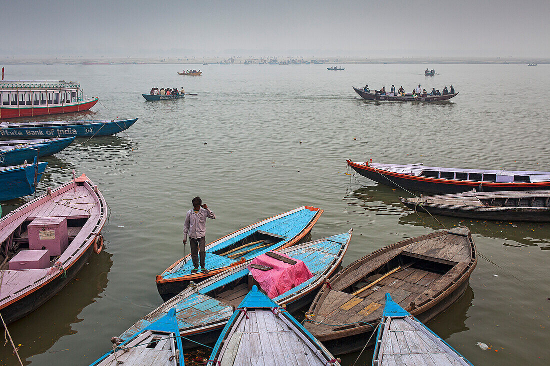 Fischer, im Hintergrund Boote der Pilger, im Fluss Ganges, Varanasi, Uttar Pradesh, Indien.