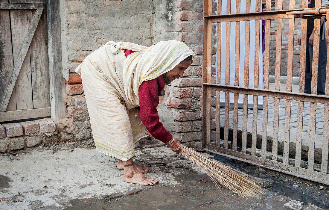 Witwe beim Reinigen ihres Ashrams, Vrindavan, Mathura-Distrikt, Indien