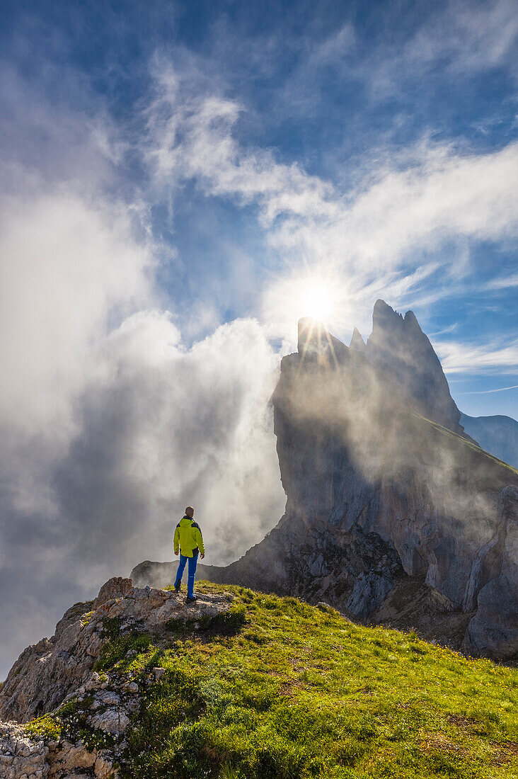 Ein Mann beobachtet die Seceda während des Sonnenaufgangs, Geiselgruppe, Grödner Dolomiten, Bozen, Trentino Südtirol, Italien, Südeuropa (MR)