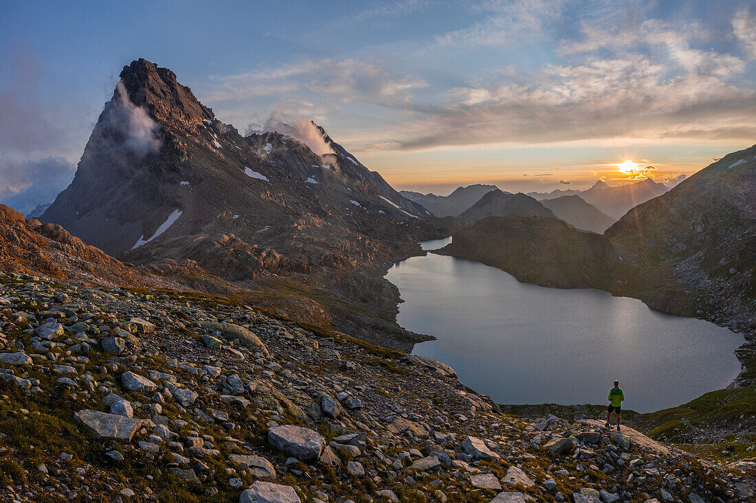 Aerial view of a Man at Rossa Pass and Geisspfadsee at sunset during summer, Alpe Devero, Val D’Ossola, Verbano Cusio Ossola, Piedmont, Italy, Western Europe