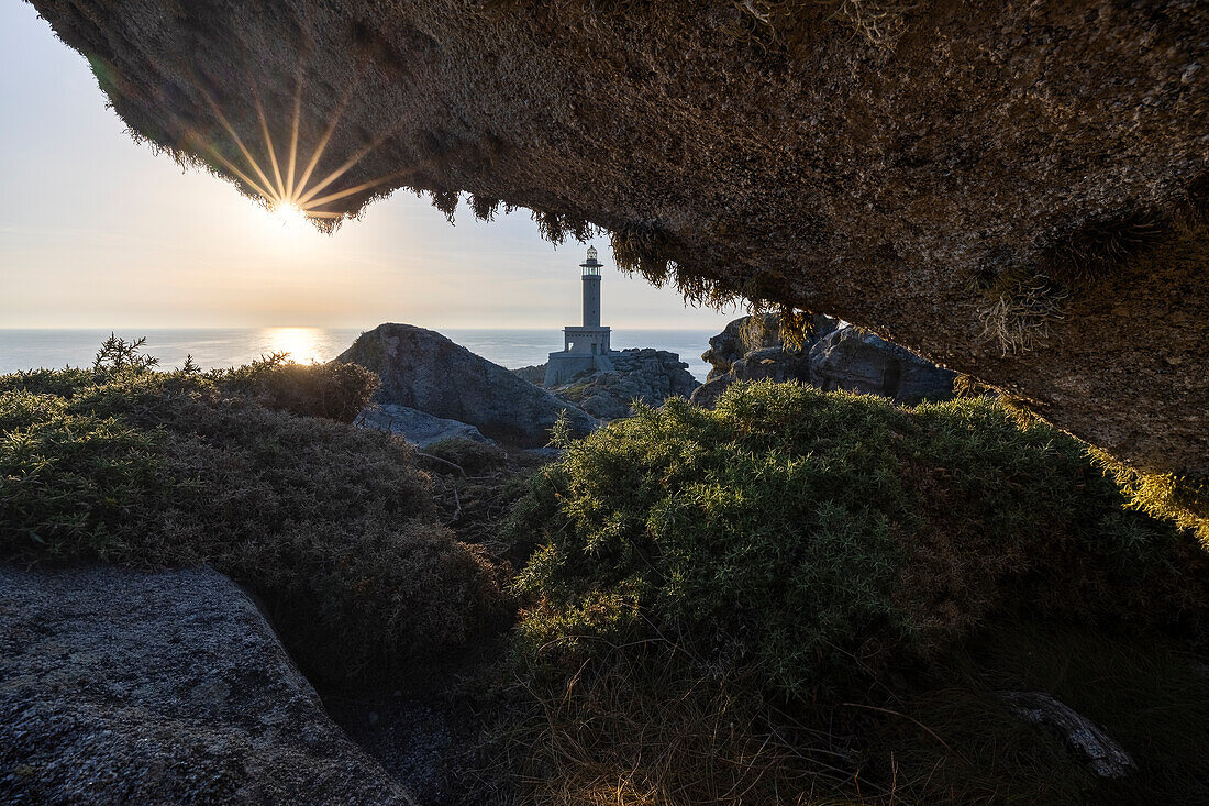 Leuchtturm Punta Nariga bei Sonnenuntergang von einer Höhle aus, Costa da Morte, Galicien, Spanien, Iberische Halbinsel, Westeuropa