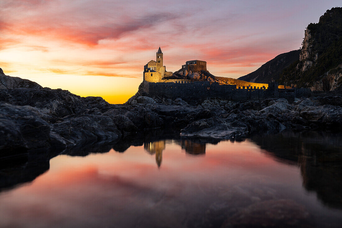 Chiesa di San Pietro illuminated and reflected at sunset from Isola Palmaria, Portovenere, La Spezia, Liguria, Italy, Southern Europe