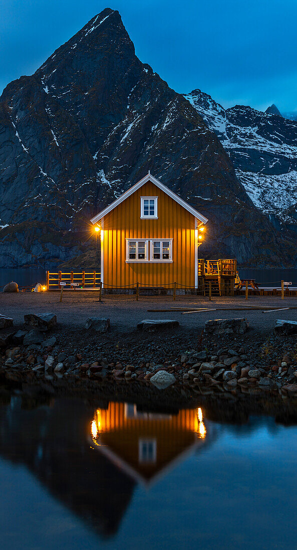 Gelbe Hütte in Sakrisoy während der blauen Stunde vor dem Berg Olstind, Moskenes, Moskenesoya, Nordland, Lofoten, Norwegen, Nordeuropa