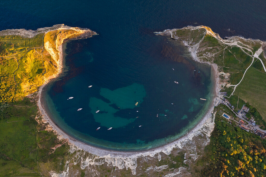 Aerial view of Lulworth Cove at sunset with boats, Durdle Door, Dorset, United Kingdom, Northern Europe