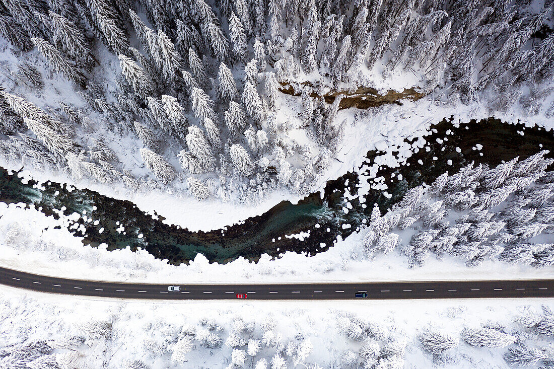 Luftaufnahme von Autos, die auf einer Bergstraße im Winter fahren, Graubünden, Engadin, Schweiz