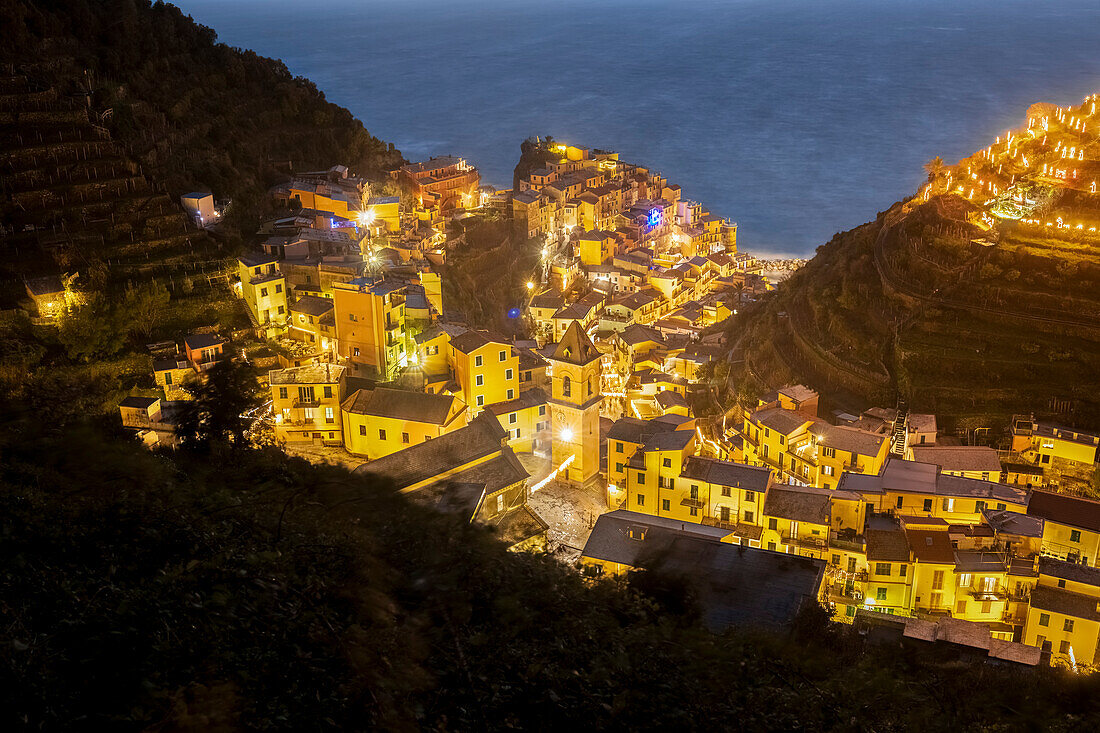Die Lichter des Meeresdorfes Vernazza mit der typischen Krippe auf dem Hügel, Nationalpark Cinque Terre, Provinz La Spezia, Ligurien, Italien.