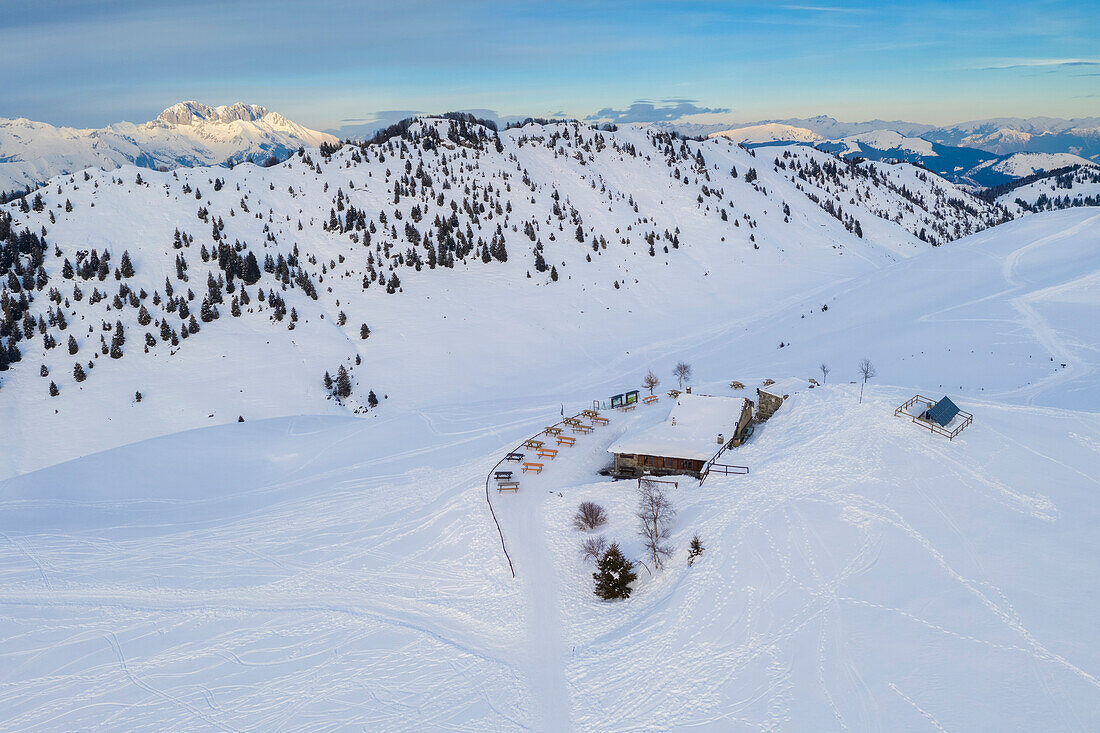 Luftaufnahme der Parafulmine-Hütte, des Monte Farno und des Presolana-Massivs im Hintergrund, das mit Schnee bedeckt ist. Monte Farno, Gandino, Valgandino, Val Seriana, Provinz Bergamo, Lombardei, Italien.