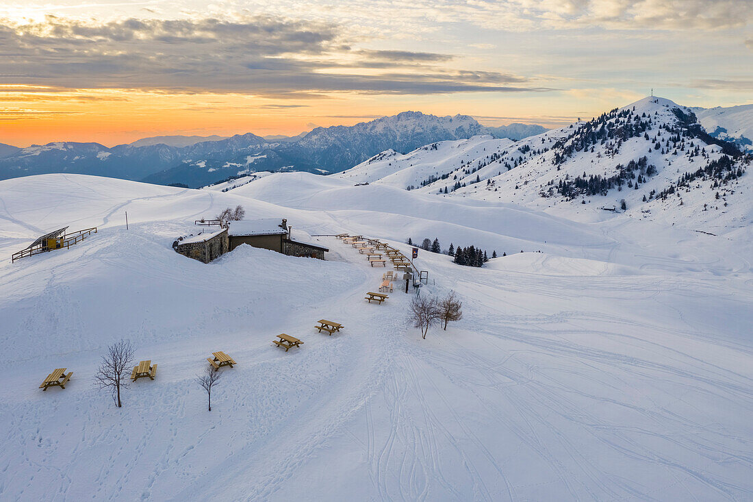 Luftaufnahme der Parafulmine-Hütte, des Monte Farno und des Pizzo Formico im Winter bei Sonnenuntergang. Monte Farno, Gandino, Valgandino, Serianatal, Provinz Bergamo, Lombardei, Italien.