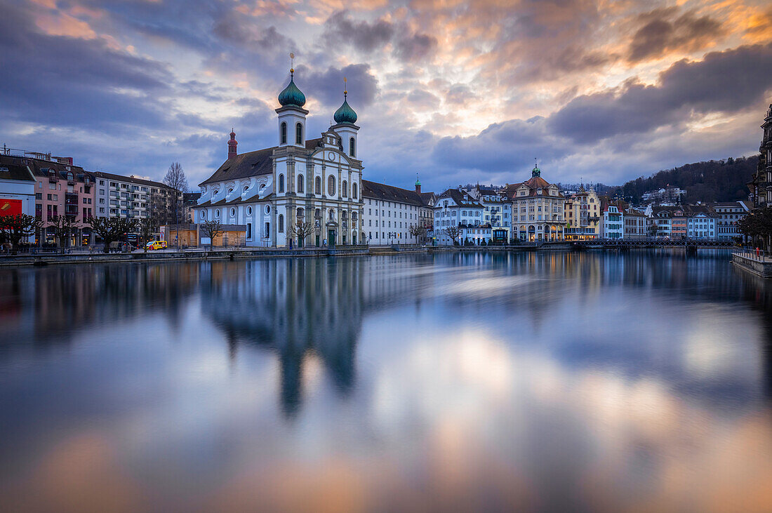 View of the Jesuit Church and the old town of Lucerne at sunset reflected on the Reuss river. Lucerne, canton of Lucerne, Switzerland.