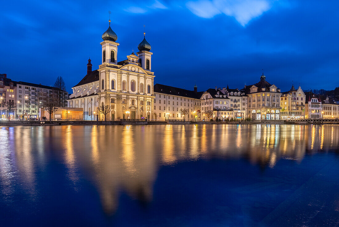 View of the Jesuit Church and the old town of Lucerne at blue hour reflected on the Reuss river. Lucerne, canton of Lucerne, Switzerland.