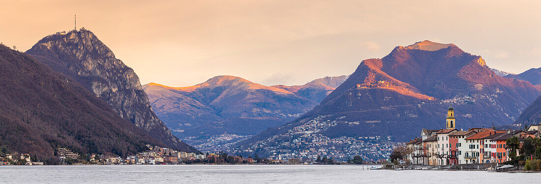 Sonnenaufgang in Brusino Arsizio und Lugano in der Ferne, Ceresio-See, Kanton Tessin, Schweiz.